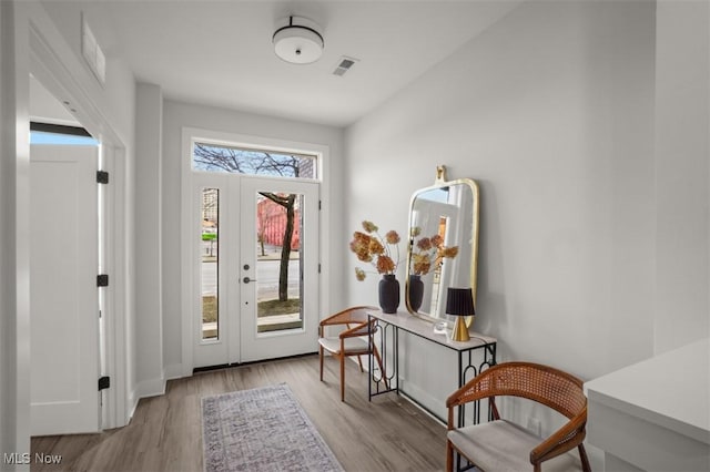 doorway to outside with wood finished floors and visible vents