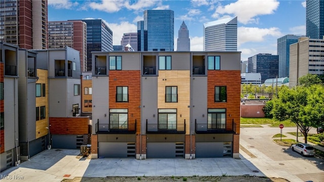 exterior space featuring a view of city, driveway, and an attached garage