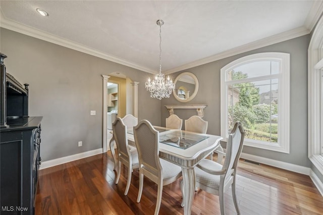 dining room with visible vents, dark wood-style floors, arched walkways, an inviting chandelier, and baseboards