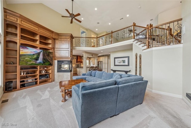 carpeted living area with baseboards, a multi sided fireplace, recessed lighting, high vaulted ceiling, and a ceiling fan