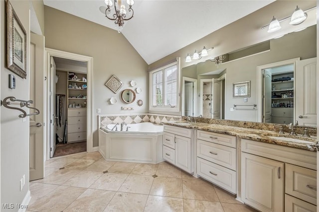 full bath featuring tile patterned floors, a bath, lofted ceiling, and a sink