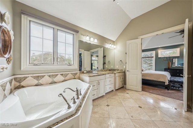 ensuite bathroom with a garden tub, ensuite bathroom, ceiling fan, vanity, and vaulted ceiling