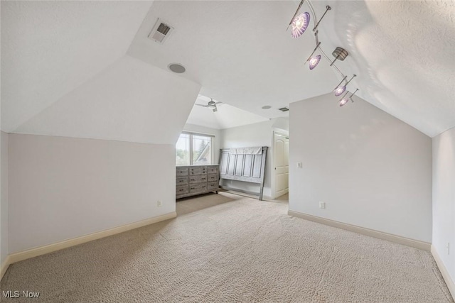 additional living space featuring visible vents, baseboards, carpet, and vaulted ceiling