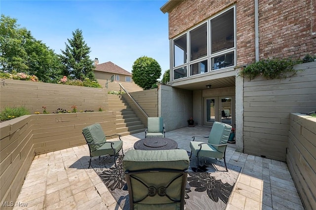 view of patio with french doors, stairs, and fence