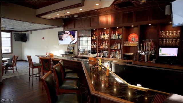 bar featuring a community bar and dark wood-style flooring