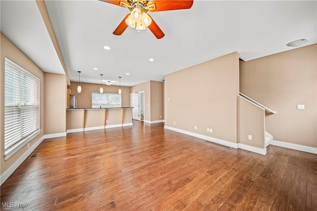 unfurnished living room with ceiling fan and light hardwood / wood-style floors