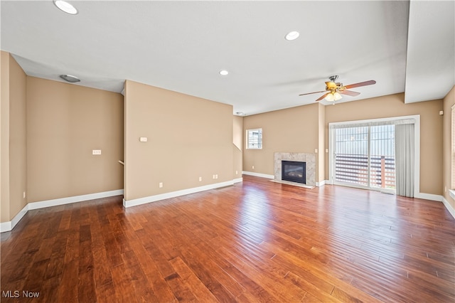 unfurnished living room with a fireplace, ceiling fan, and wood-type flooring