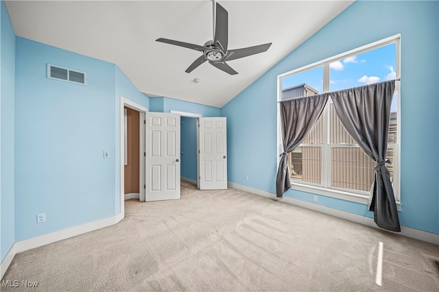 unfurnished bedroom with vaulted ceiling, light colored carpet, and ceiling fan