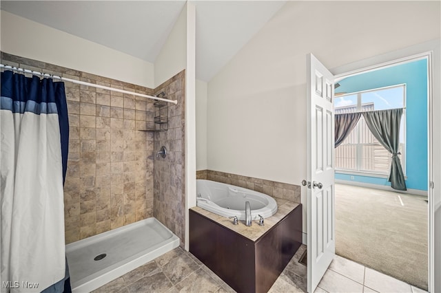 bathroom with plus walk in shower, lofted ceiling, and tile patterned flooring