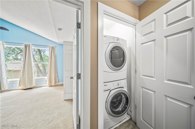 washroom with stacked washer / drying machine and light colored carpet