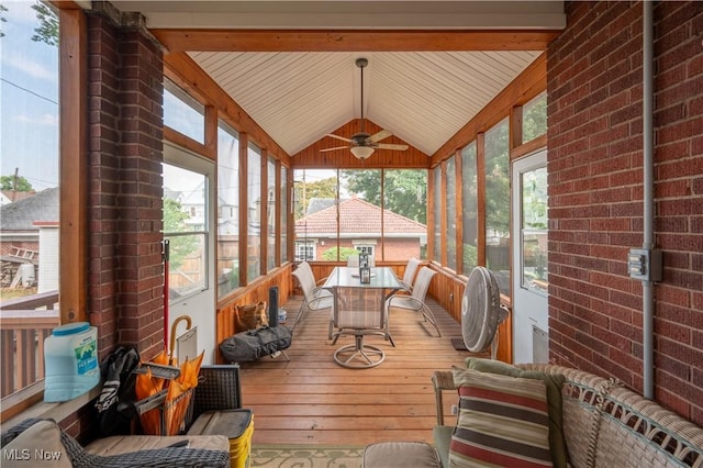 sunroom / solarium with ceiling fan, vaulted ceiling, and plenty of natural light