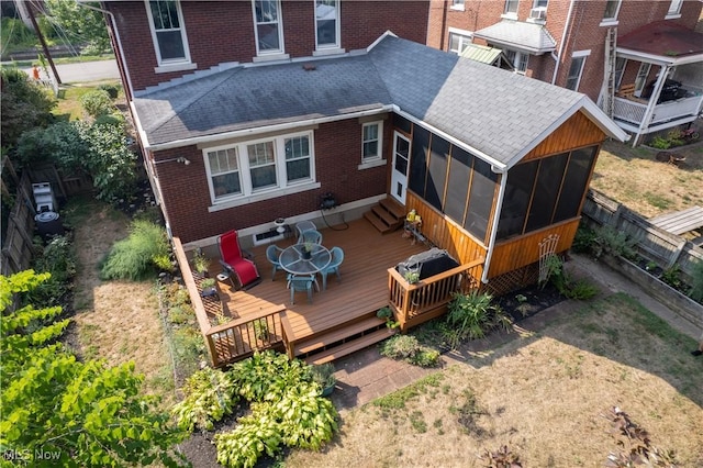 rear view of house featuring a sunroom and a wooden deck