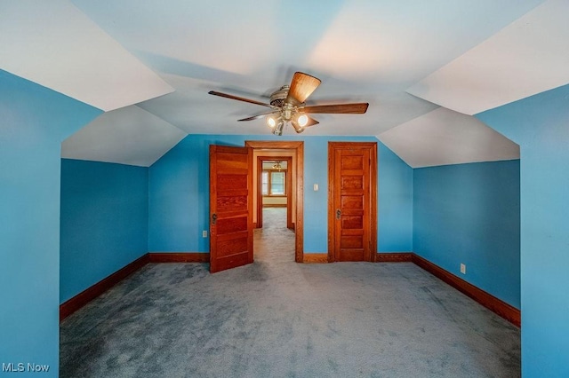 additional living space with ceiling fan, lofted ceiling, and dark carpet