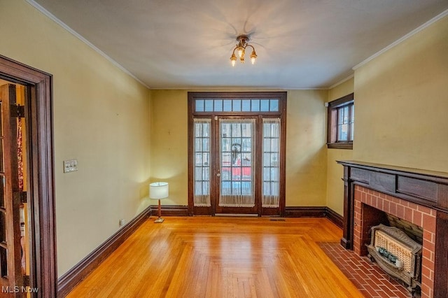 unfurnished living room featuring a fireplace, light parquet flooring, and crown molding