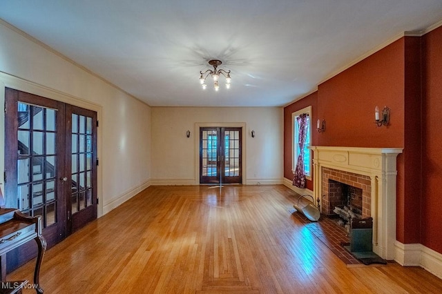 unfurnished living room with french doors, a fireplace, and light wood-type flooring