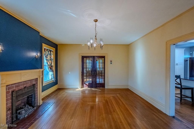 living room with french doors, hardwood / wood-style flooring, a chandelier, and a fireplace