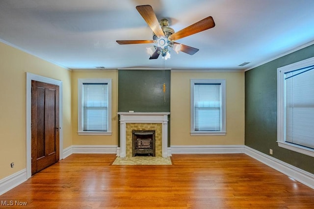 unfurnished living room featuring ornamental molding, ceiling fan, light hardwood / wood-style floors, and plenty of natural light