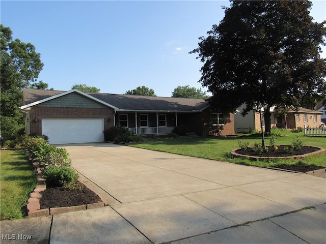 ranch-style house featuring a garage, covered porch, and a front lawn