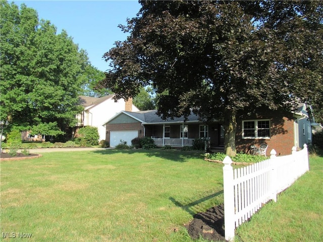 view of front of home with a garage, covered porch, and a front lawn