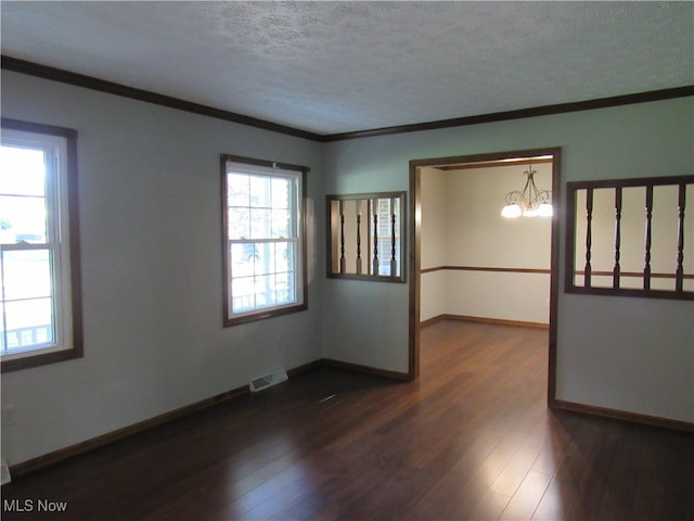 spare room with crown molding, dark hardwood / wood-style floors, and a wealth of natural light