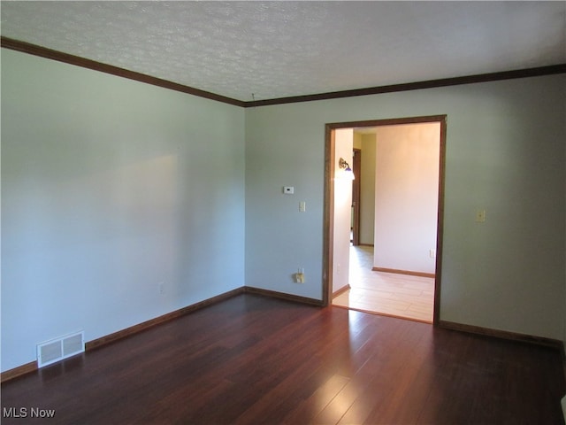 empty room with hardwood / wood-style flooring, ornamental molding, and a textured ceiling