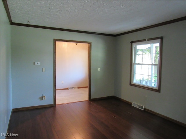 spare room with ornamental molding, dark wood-type flooring, and a textured ceiling