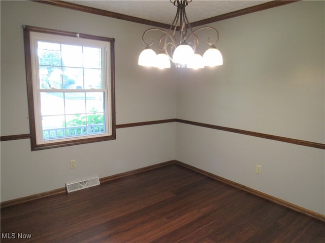 unfurnished room featuring a notable chandelier, dark wood-type flooring, and ornamental molding