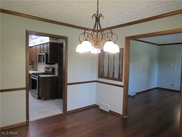 unfurnished dining area featuring an inviting chandelier, crown molding, hardwood / wood-style floors, and a textured ceiling