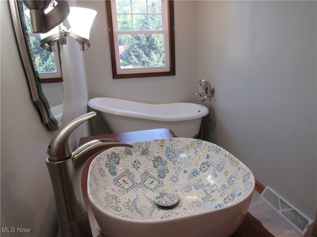 bathroom with plenty of natural light and a tub to relax in