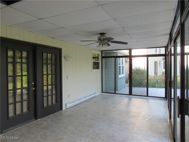 unfurnished sunroom featuring baseboard heating, ceiling fan, french doors, and a drop ceiling