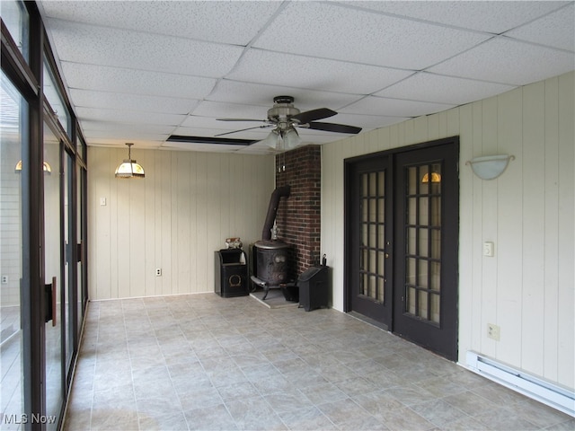 unfurnished sunroom with ceiling fan, a drop ceiling, baseboard heating, and french doors