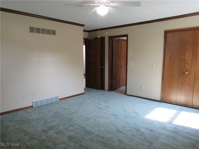 unfurnished bedroom featuring crown molding, carpet floors, a textured ceiling, and ceiling fan