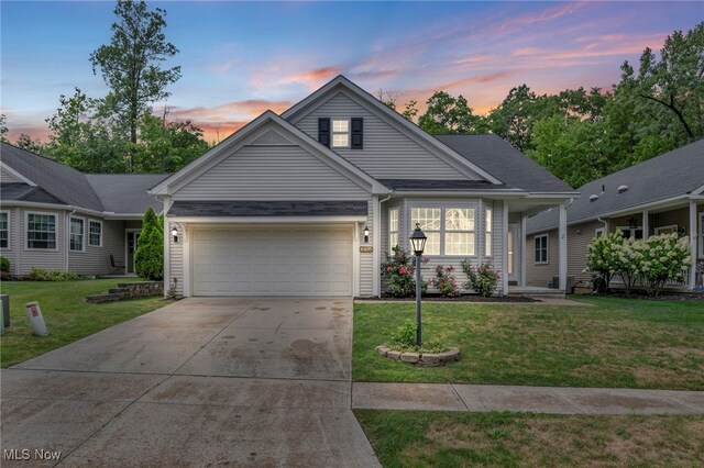 view of front of home with a garage and a yard