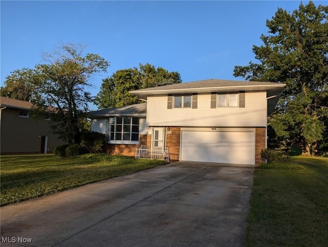 split level home featuring a garage, concrete driveway, and a front lawn