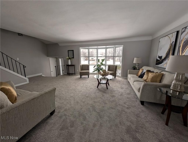 carpeted living area featuring stairs and baseboards