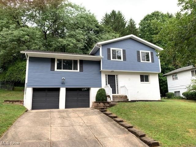 tri-level home with a garage and a front yard