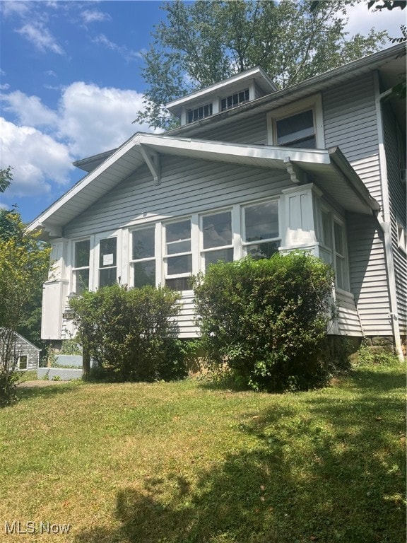 view of side of property with a lawn