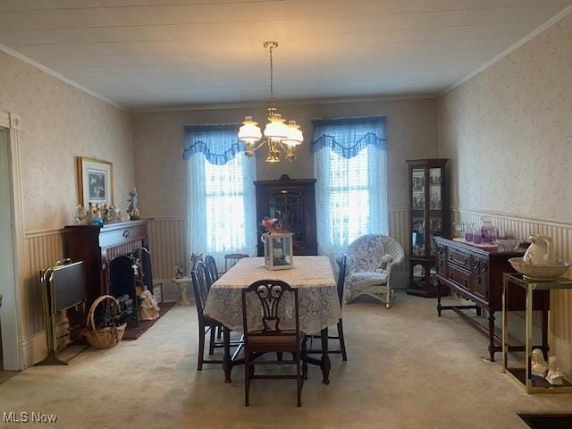 dining space featuring ornamental molding, light carpet, and a brick fireplace