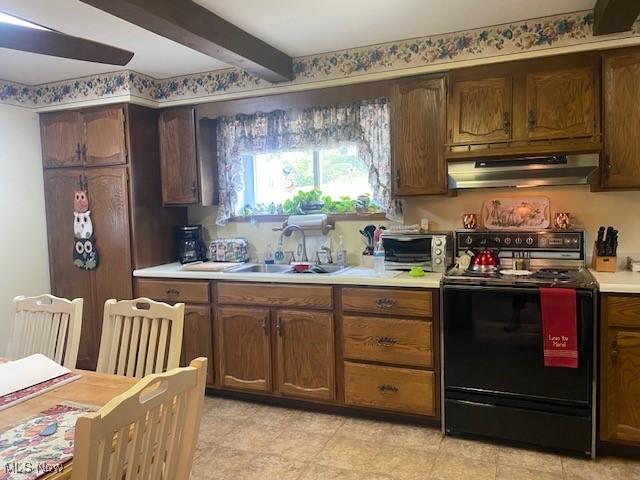 kitchen featuring black electric range, extractor fan, sink, and beamed ceiling