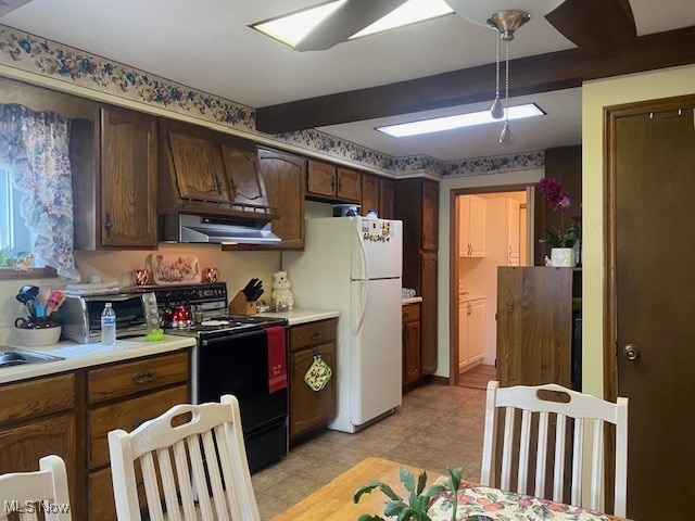 kitchen featuring white fridge, range hood, light tile patterned floors, dark brown cabinets, and black electric range oven