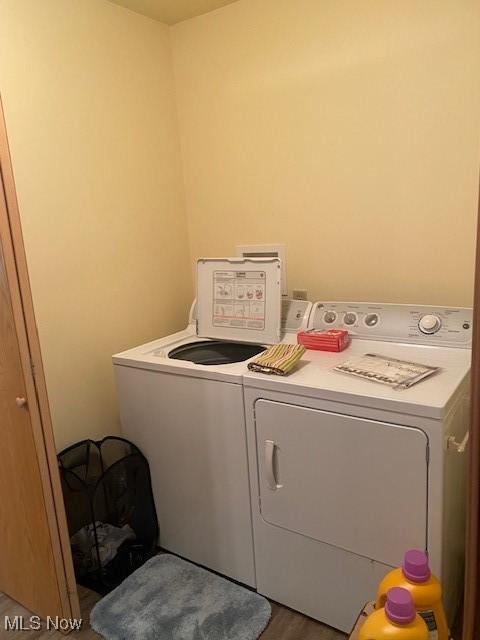 washroom with washing machine and dryer and dark hardwood / wood-style flooring