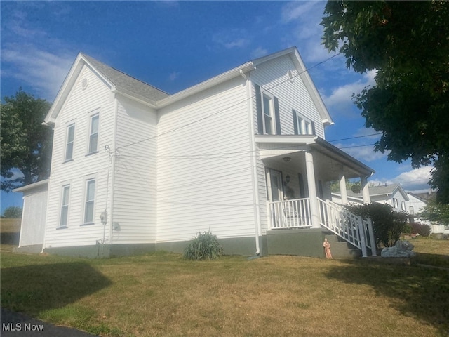 view of side of property featuring a yard and covered porch