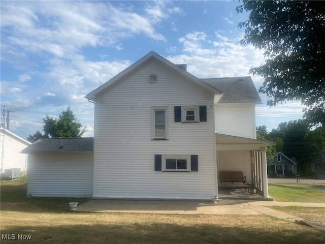 back of property with a yard and a patio area