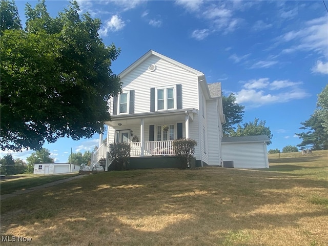 view of front of house with a front yard, central air condition unit, and covered porch