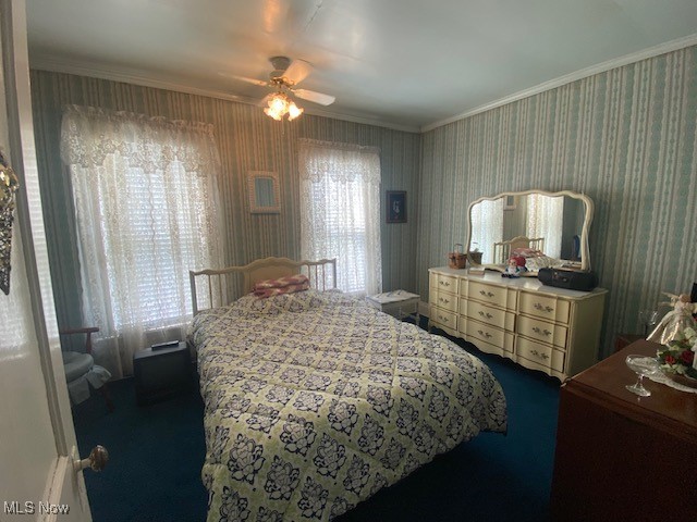 carpeted bedroom with ornamental molding and ceiling fan