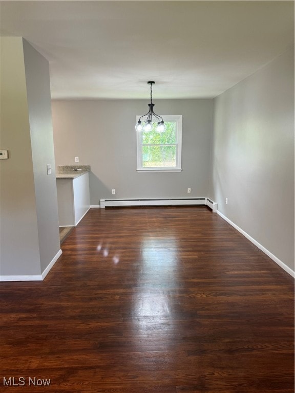 unfurnished room featuring a chandelier, dark hardwood / wood-style floors, and a baseboard heating unit