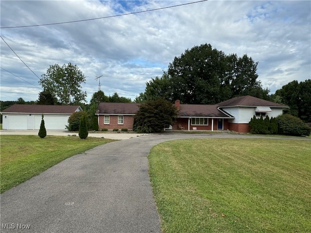 1717 Stillwagon Rd, Niles, OH 44446 - view of front of home featuring brick siding, a front yard, driveway, and a detached garage