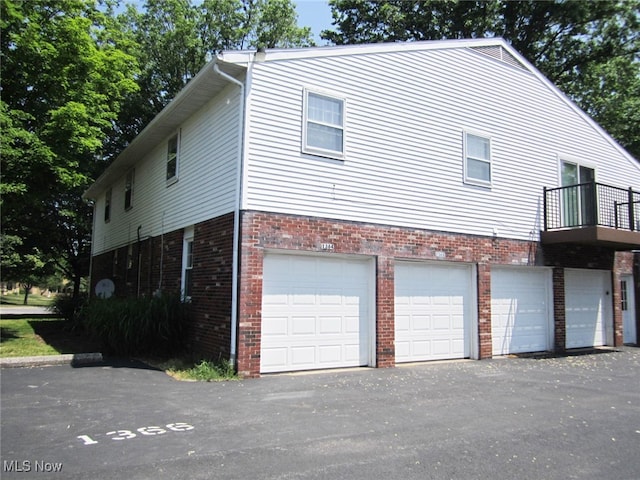 view of property exterior featuring a balcony and a garage