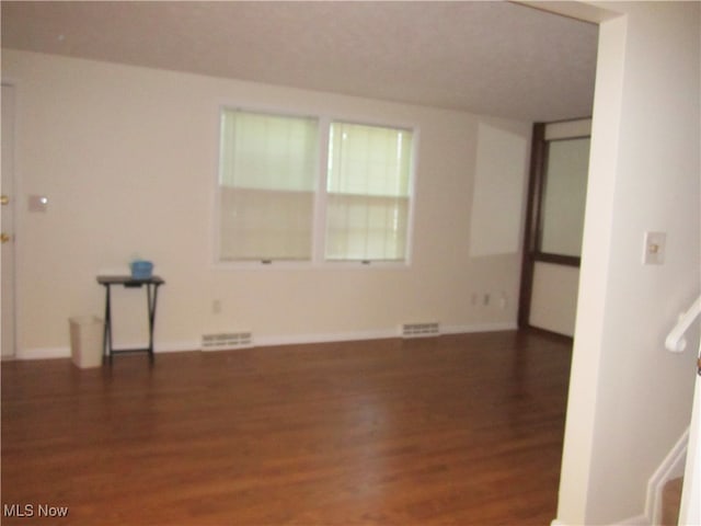 unfurnished room with dark hardwood / wood-style flooring