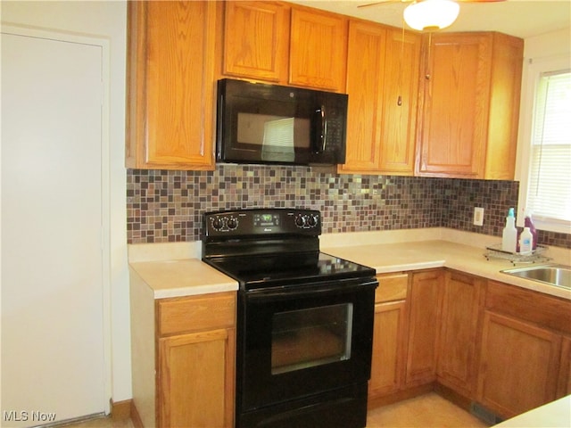 kitchen featuring ceiling fan, tasteful backsplash, black appliances, and sink